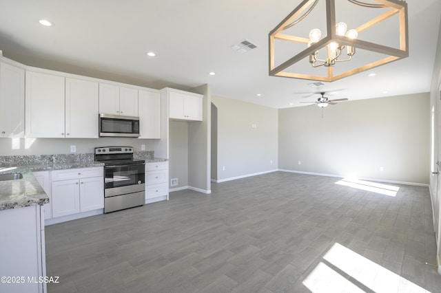 kitchen featuring stainless steel appliances, light wood-type flooring, pendant lighting, ceiling fan with notable chandelier, and white cabinets