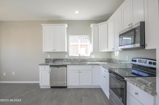 kitchen featuring white cabinets, dark stone counters, sink, and stainless steel appliances