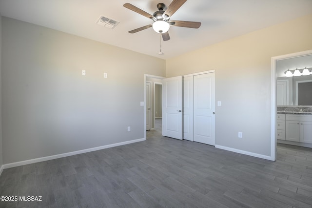 unfurnished bedroom with wood-type flooring, sink, a closet, ceiling fan, and ensuite bathroom