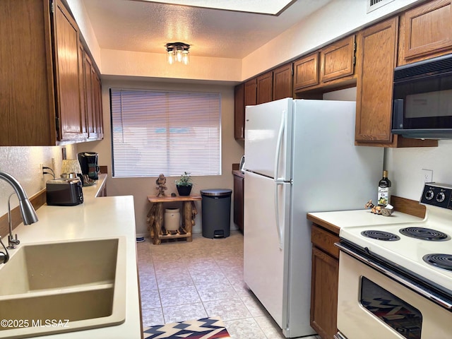 kitchen featuring white electric stove, sink, and light tile patterned floors