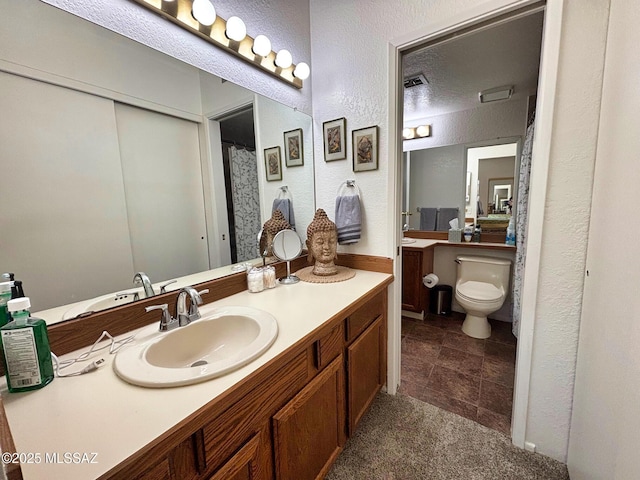 bathroom with vanity, a textured ceiling, and toilet