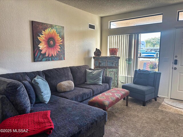 living room with light colored carpet, a fireplace, and a textured ceiling