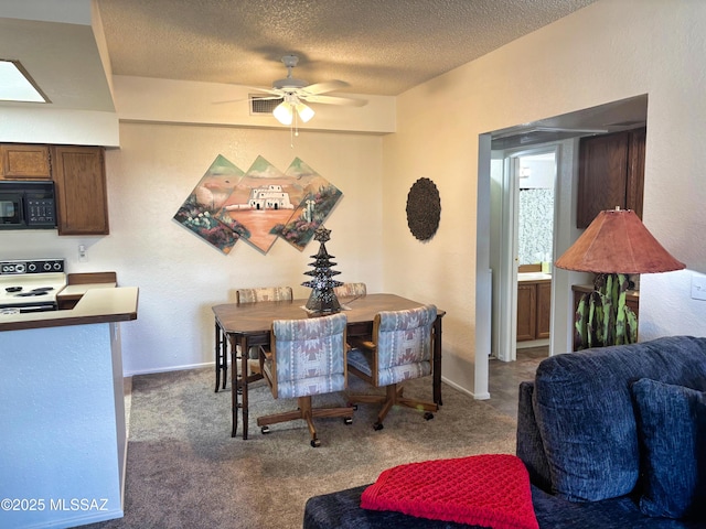 dining space with ceiling fan, a textured ceiling, and dark colored carpet