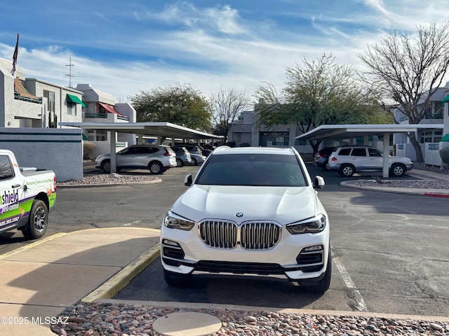 view of parking / parking lot featuring a carport