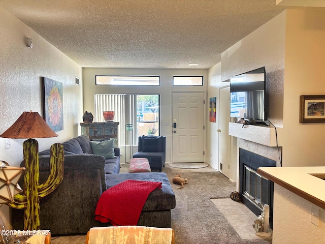 living room featuring a textured ceiling, light carpet, and a tiled fireplace