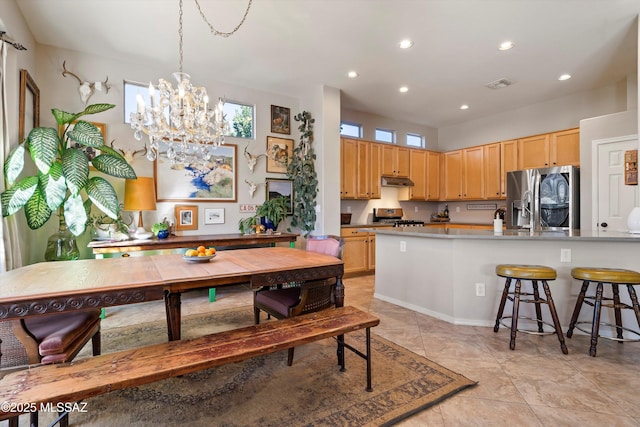 tiled dining room with a chandelier