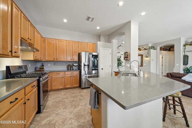 kitchen featuring kitchen peninsula, sink, light stone countertops, a breakfast bar area, and stainless steel appliances