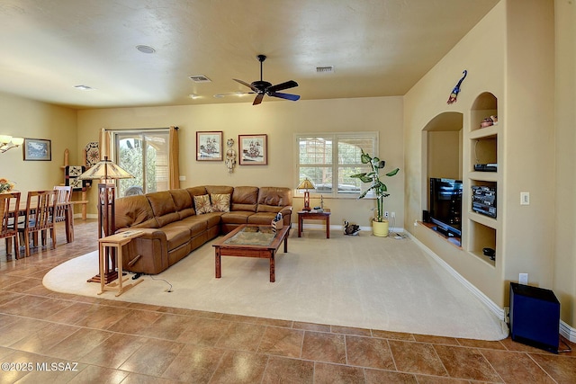 living room featuring tile patterned flooring, a wealth of natural light, built in features, and ceiling fan