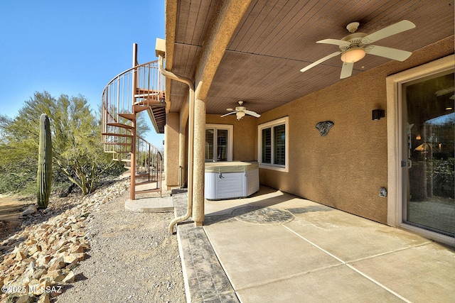 view of patio / terrace featuring ceiling fan and a hot tub