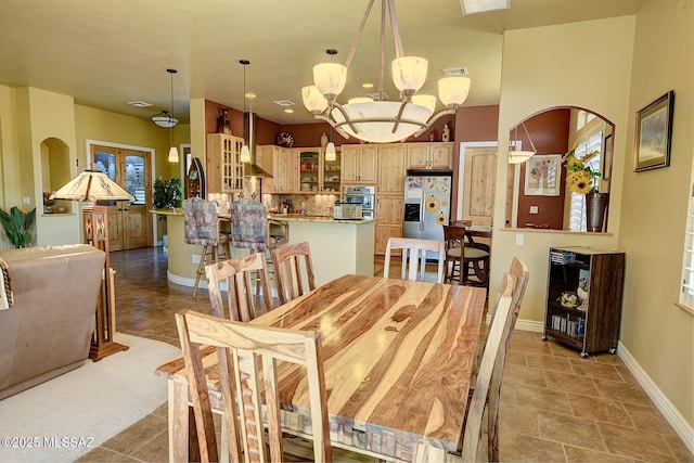 tiled dining room with a chandelier