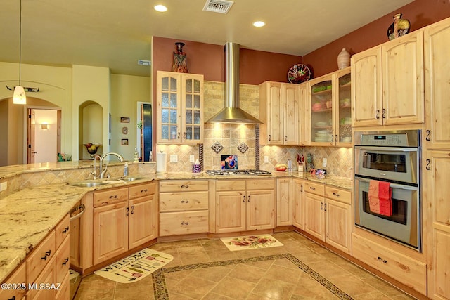 kitchen featuring light brown cabinetry, sink, decorative backsplash, and wall chimney exhaust hood