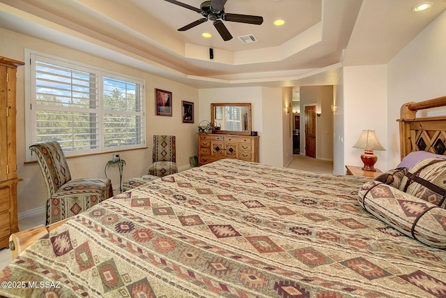 bedroom with a tray ceiling and ceiling fan