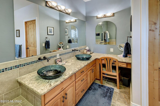 bathroom with vanity and tasteful backsplash