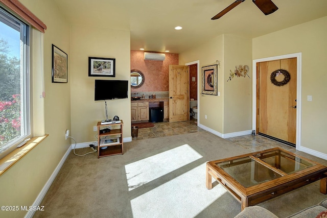 carpeted living room featuring a wall unit AC and ceiling fan