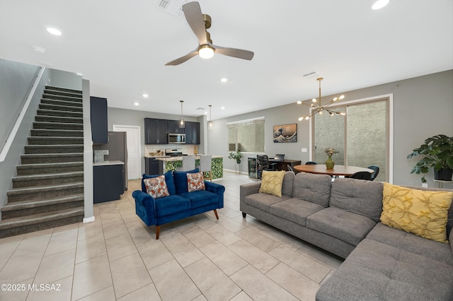 tiled living room with ceiling fan with notable chandelier