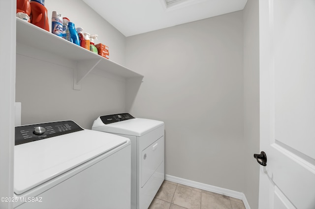 clothes washing area with washer and clothes dryer and light tile patterned floors