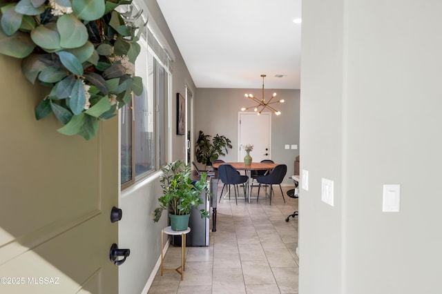 corridor featuring a notable chandelier and light tile patterned floors