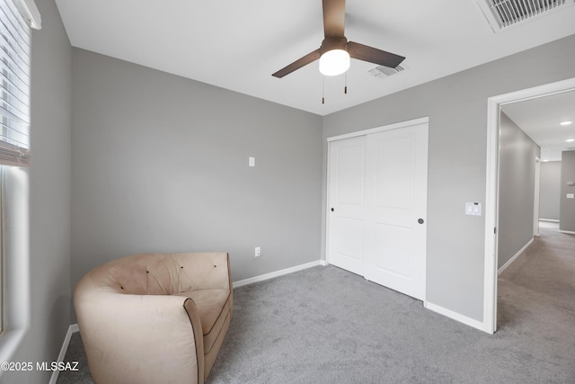 living area with carpet flooring and ceiling fan