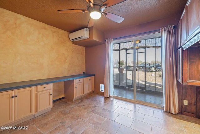 interior space featuring a textured ceiling, built in desk, an AC wall unit, and ceiling fan