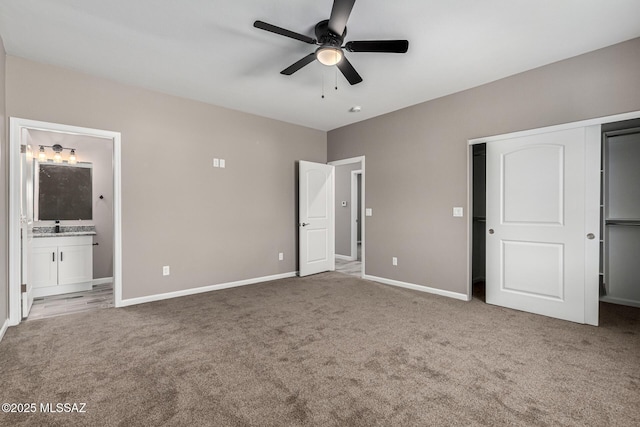 unfurnished bedroom featuring ceiling fan, sink, ensuite bath, and carpet flooring