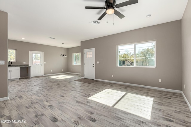 unfurnished living room with ceiling fan and light wood-type flooring