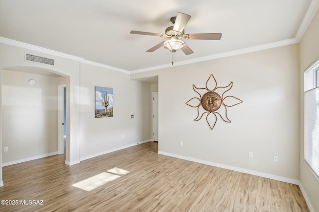 spare room with a wealth of natural light, ornamental molding, ceiling fan, and light wood-type flooring