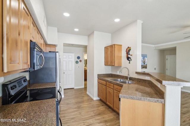 kitchen with appliances with stainless steel finishes, sink, light hardwood / wood-style flooring, and kitchen peninsula