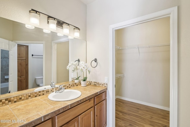 bathroom featuring wood-type flooring, vanity, and toilet