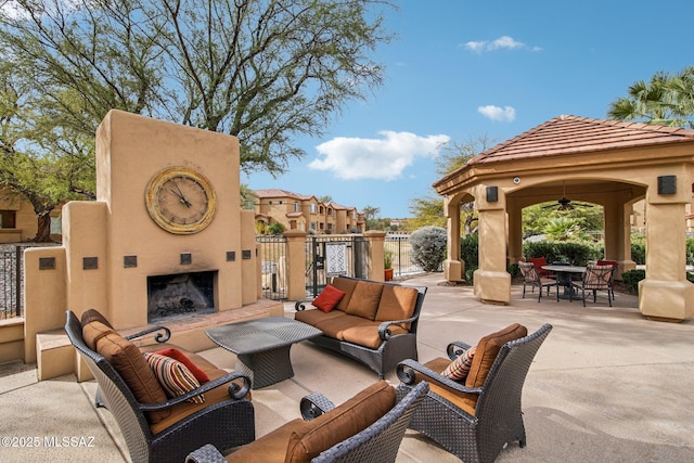 view of patio featuring a gazebo, an outdoor living space with a fireplace, and ceiling fan