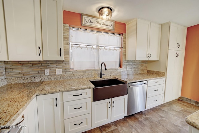 kitchen with sink, white cabinets, dishwasher, and light stone counters