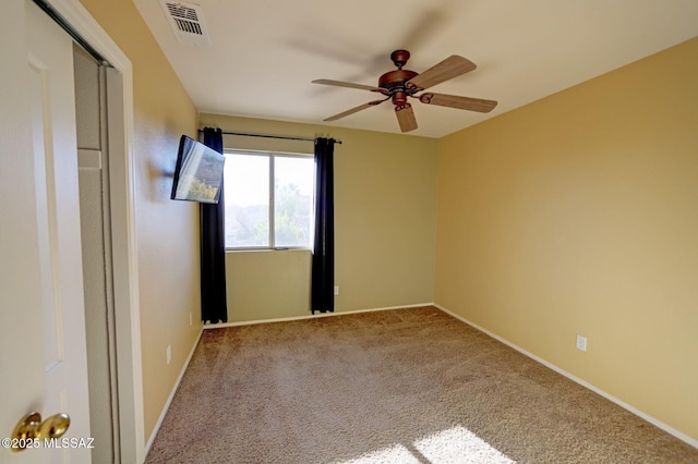 carpeted spare room featuring ceiling fan