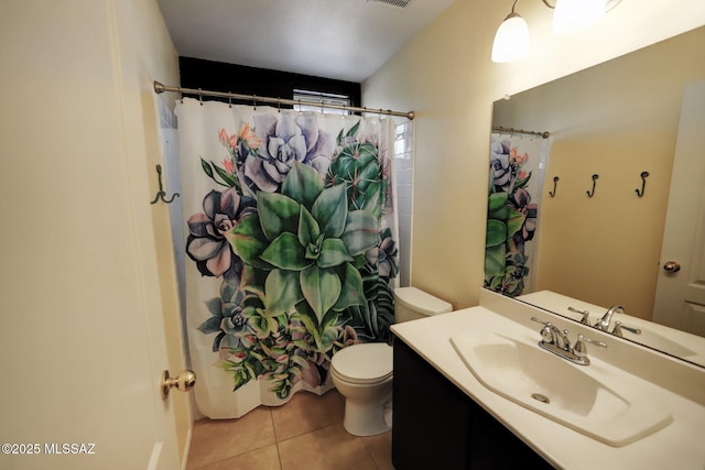 bathroom featuring toilet, tile patterned flooring, walk in shower, and vanity