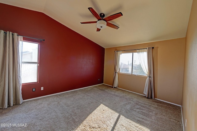 unfurnished room featuring ceiling fan, a wealth of natural light, light carpet, and lofted ceiling