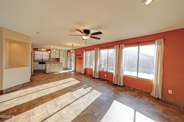 unfurnished living room with ceiling fan