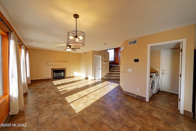 unfurnished living room featuring ceiling fan and washer and clothes dryer