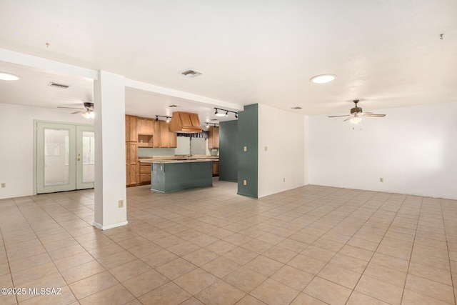 unfurnished living room featuring light tile patterned floors, french doors, and ceiling fan