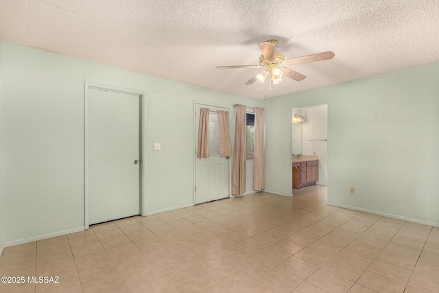 unfurnished bedroom with ceiling fan, connected bathroom, and a textured ceiling