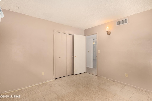 unfurnished bedroom with a textured ceiling and a closet