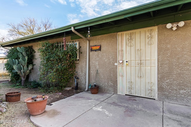 view of exterior entry featuring a patio area