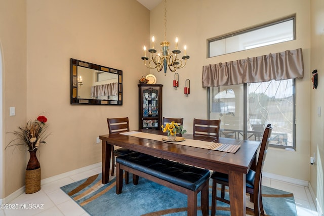 dining area featuring a towering ceiling, a notable chandelier, and light tile patterned floors