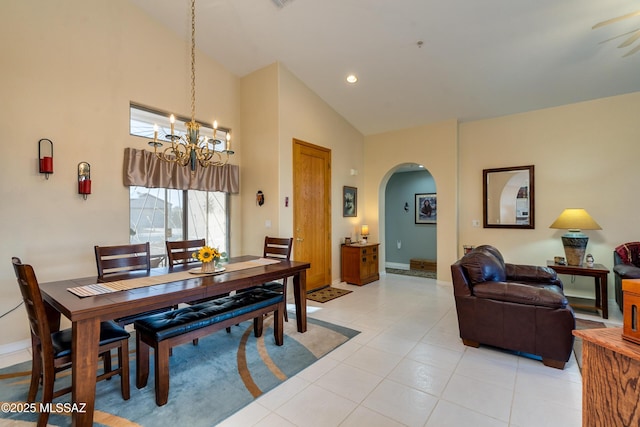 dining area with light tile patterned flooring, high vaulted ceiling, and a notable chandelier