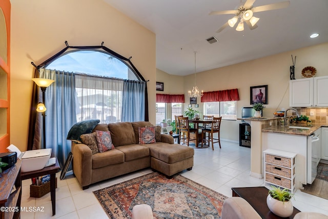 living room with ceiling fan with notable chandelier, sink, and light tile patterned floors