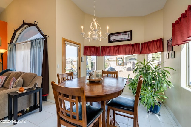 dining space featuring light tile patterned flooring, a chandelier, and high vaulted ceiling