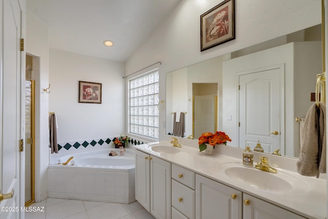 bathroom featuring lofted ceiling, tiled bath, tile patterned flooring, and vanity