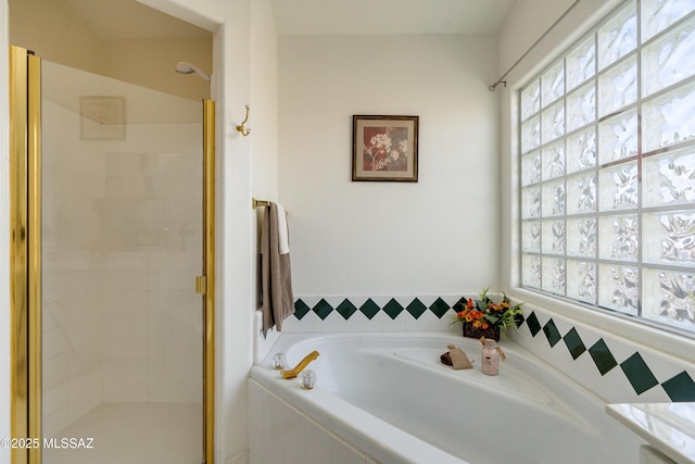 bathroom featuring independent shower and bath