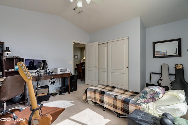 bedroom with light carpet, lofted ceiling, a closet, and ceiling fan