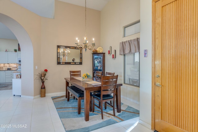 dining space with a notable chandelier, a high ceiling, and light tile patterned flooring