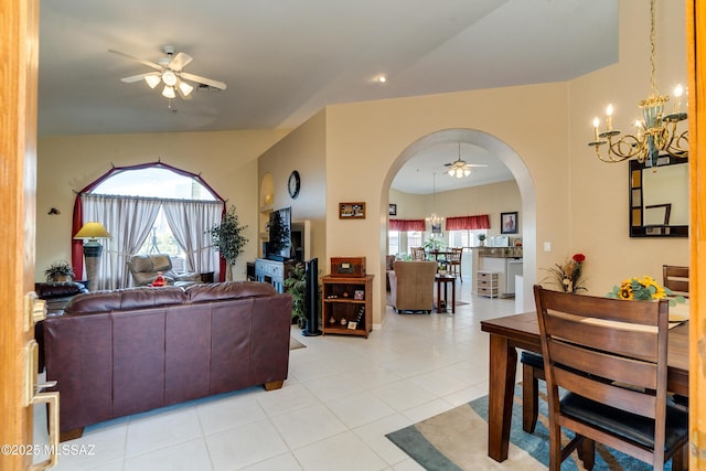 tiled living room featuring plenty of natural light and ceiling fan with notable chandelier