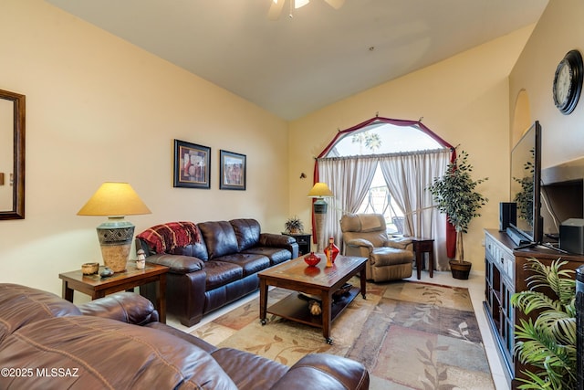 living room with ceiling fan, vaulted ceiling, and light tile patterned floors