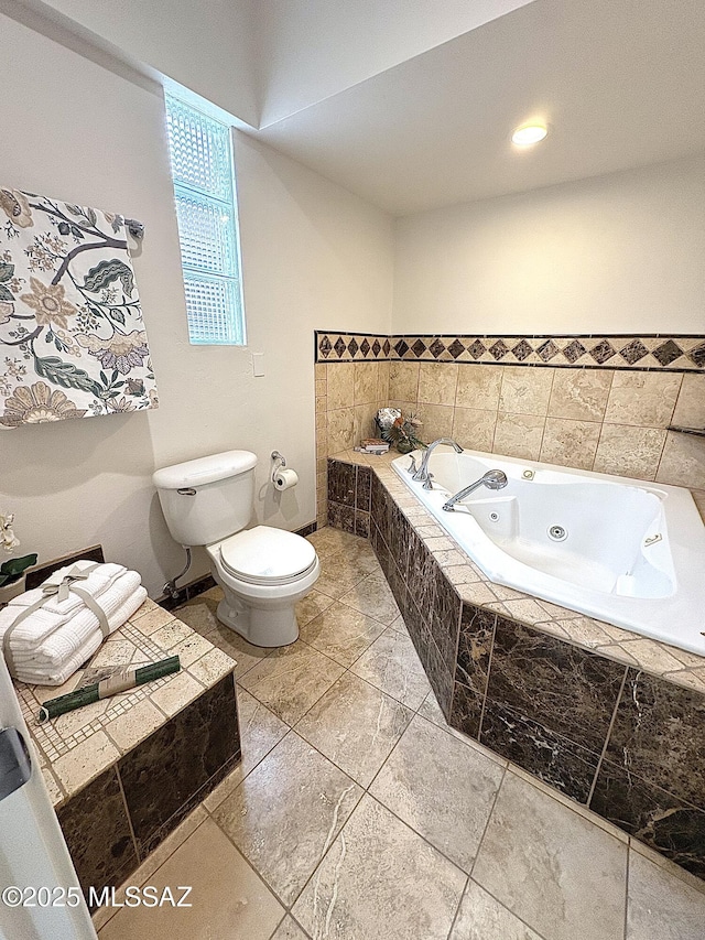 bathroom featuring tiled tub and toilet